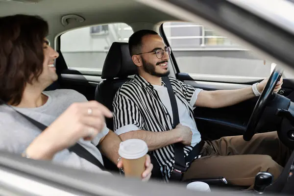 A happy gay couple drives, enjoying coffee and each other's company. — Stock Photo