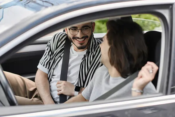 A gay couple smiles and laughs while riding in a car. — Stock Photo
