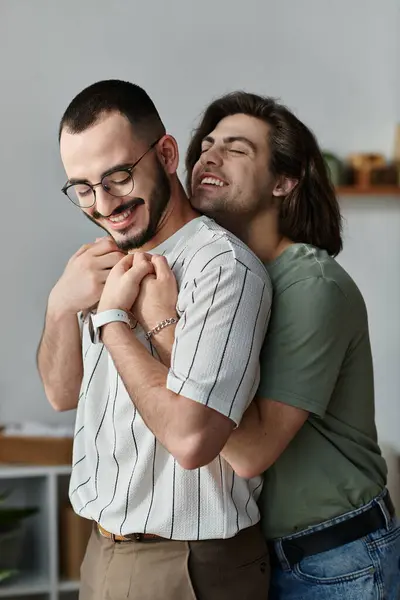 Two men embrace with affection and laughter in a shared home. — Stock Photo