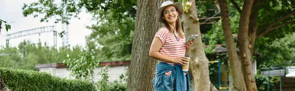 Eine junge Frau mit Beinprothese lächelt, als sie an einem Baum in einem Park steht und einen Sommertag genießt. — Stockfoto