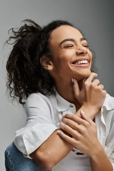 A young woman with beautiful, curly hair laughs, her joy radiating. — Stock Photo
