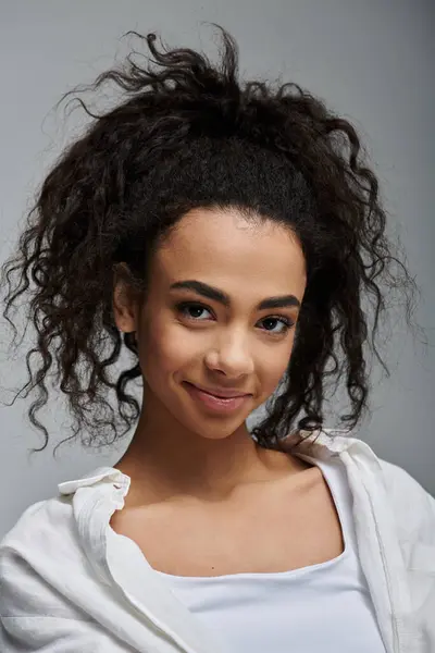 Uma jovem afro-americana com cabelo encaracolado sorri calorosamente. — Fotografia de Stock