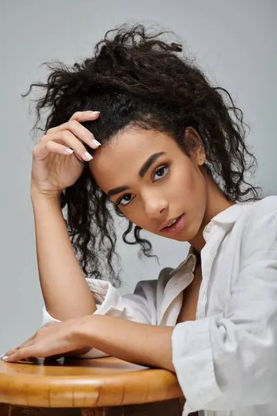 A young Black woman poses in a white shirt, resting her chin on her hand, showcasing natural beauty. — Stock Photo