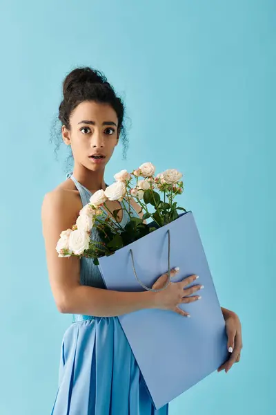 Uma jovem mulher em um vestido azul segura um buquê de flores, parecendo surpreso. — Fotografia de Stock