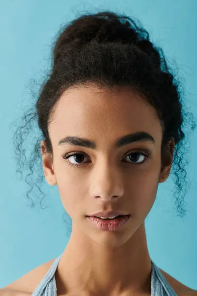 A young woman with curly hair gazes directly at the camera with a confident expression. — Stock Photo