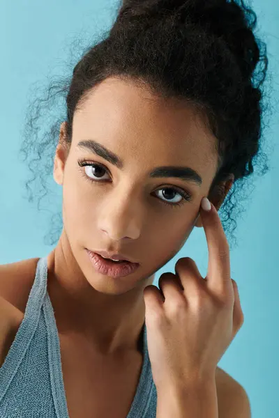 Una giovane donna con i capelli ricci scuri guarda pensieroso nella fotocamera. — Foto stock