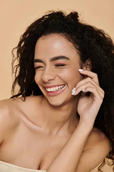 Una giovane donna con bellissimi riccioli scuri sorride radiosamente, il suo trucco naturale esaltando le sue caratteristiche. — Foto stock