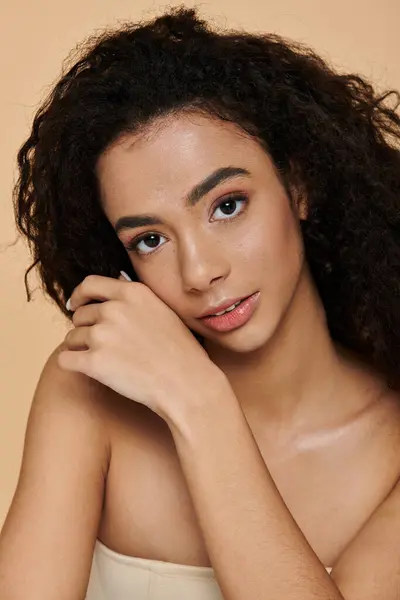 A young woman with natural makeup and bare shoulders looks directly at the camera with confidence. — Stock Photo