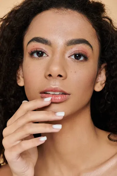 Una giovane donna afroamericana con trucco naturale e spalle nude guarda la fotocamera — Foto stock