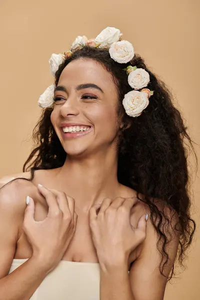 Uma jovem mulher com maquiagem natural e flores brancas em seu cabelo ri alegremente. — Fotografia de Stock