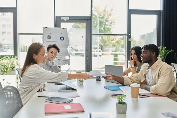 A group of young professionals work together on a startup plan in a brightly lit office. — Stock Photo