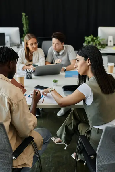 A group of coworkers collaborates at a white table in a bright, modern office. — Stock Photo