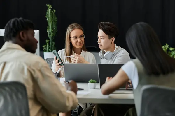 Un groupe de quatre personnes travaille ensemble sur un projet de démarrage, réfléchissant à de nouvelles idées. — Photo de stock