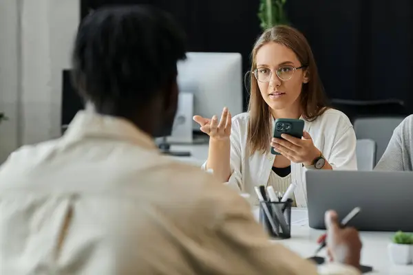 A young woman presents a mobile app idea to her team in a modern office setting. — Stock Photo