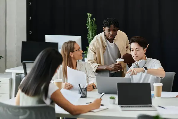 Quatro pessoas discutem em conjunto com laptops e papéis — Fotografia de Stock