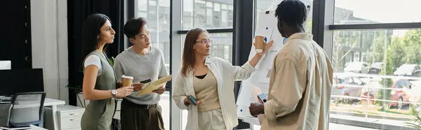 A diverse team of coworkers collaborate during a brainstorming session in a modern office. — Stock Photo