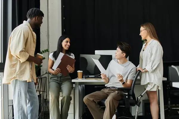 A diverse team of four works on a startup project, with one team member in a wheelchair. — Stock Photo