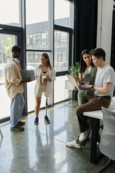 Four people collaborate on a project in a bright, open-plan office. — Stock Photo