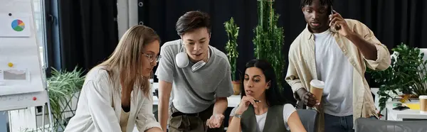 A team of four individuals work on a project in a modern office. — Stock Photo