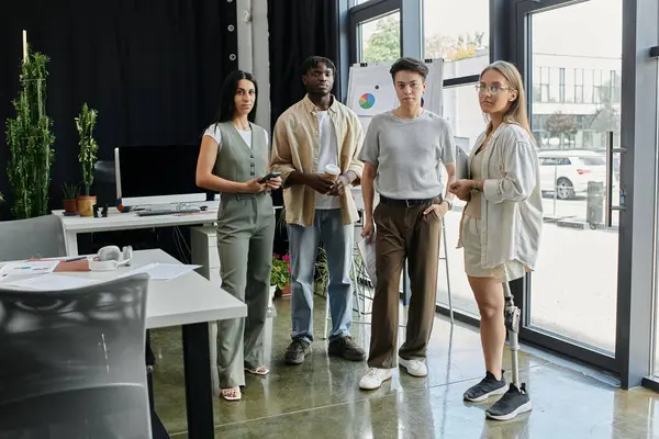 Team members, including woman with prosthetic leg, discuss project in modern office — Stock Photo