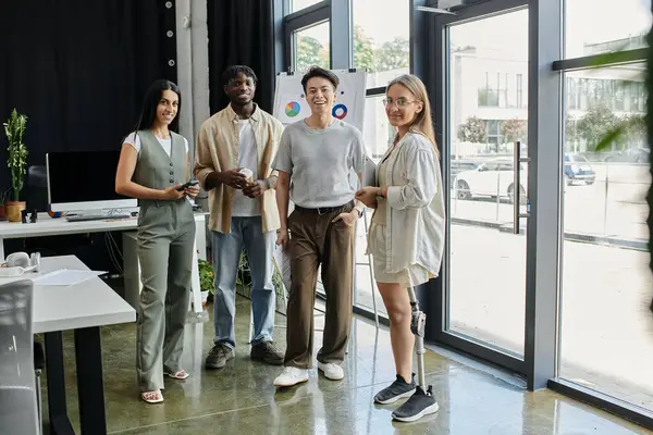 Four colleagues stand together in a bright office space. — Stock Photo