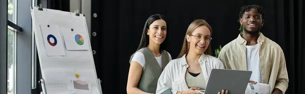 A diverse team of entrepreneurs smiles confidently as they discuss their business plan. — Stock Photo