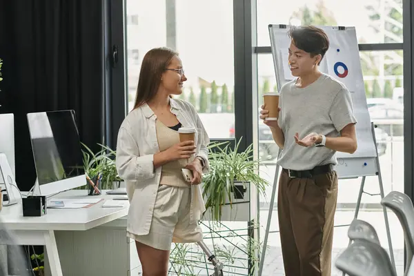 Two colleagues discuss ideas for their startup over coffee in an office. — Stock Photo