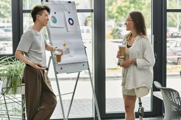 Two colleagues brainstorm startup ideas with coffee in a modern office — Stock Photo