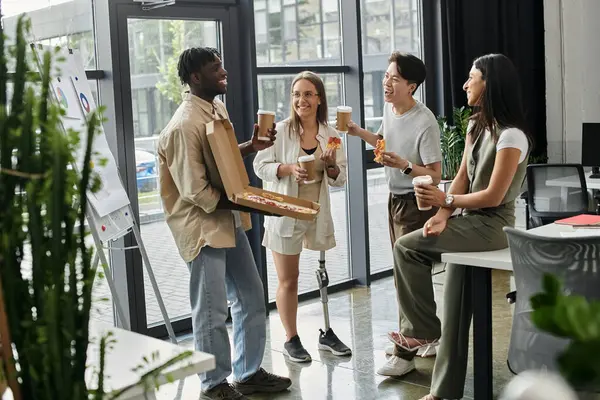 Quattro colleghi si prendono una pausa dal lavoro per condividere pizza e caffè. — Foto stock
