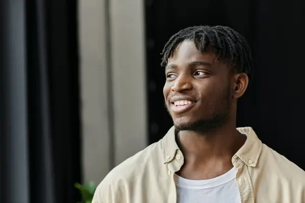 A young man smiles with confidence as he works on his startup. — Stock Photo