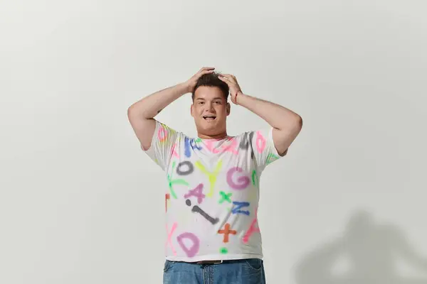 Uma pessoa queer com uma camisa colorida posa contra um fundo branco. — Fotografia de Stock