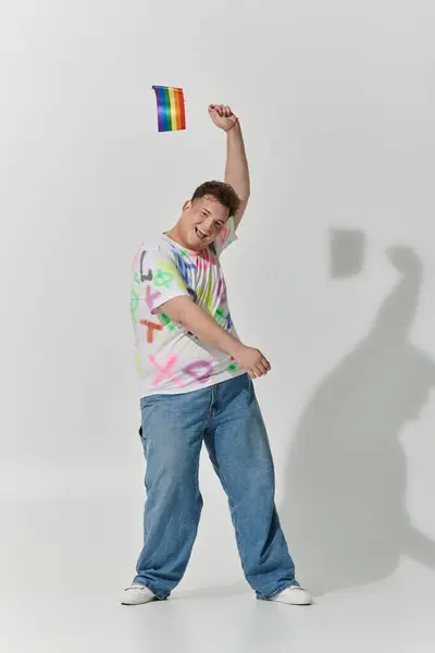 Un hombre sonríe y lanza una bandera arcoíris al aire. — Stock Photo