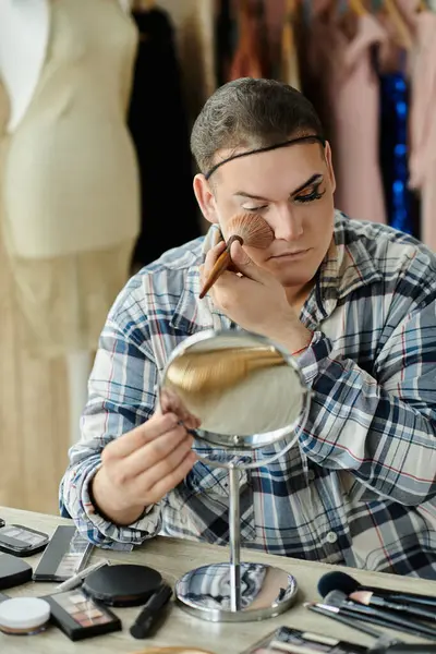 Queer person uses makeup with brushes in front of a mirror — Stock Photo