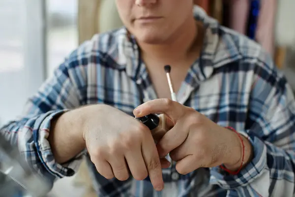 Una persona queer applica le fondamenta alla mano prima di applicarle sul viso. — Foto stock
