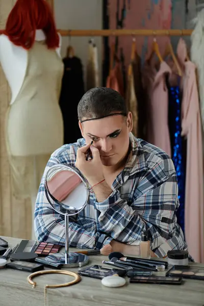 Queer person applies makeup sitting at vanity table in stylish outfit — Stock Photo