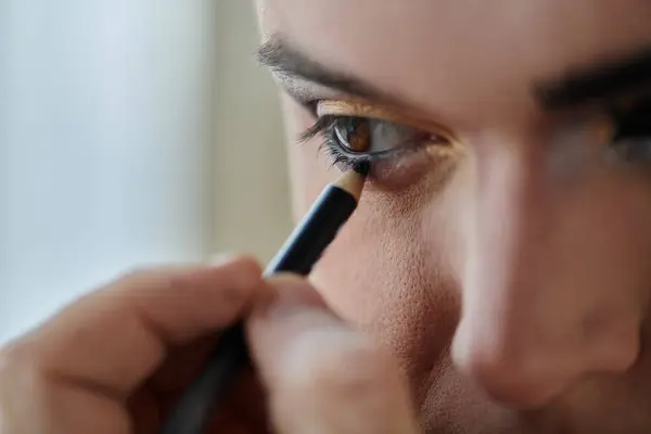 Une personne queer applique un eye-liner près de son œil. — Photo de stock