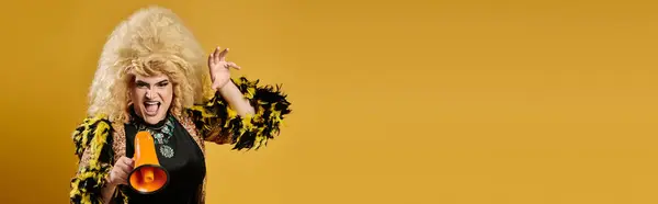 A drag queen in a vibrant outfit shouts into a megaphone. — Stock Photo