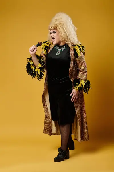 A performer in a black dress and leopard-print coat belts out a song with a microphone. — Stock Photo