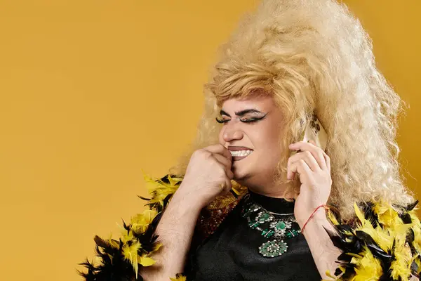 A drag queen in stylish feathered attire laughs while on a phone call. — Stock Photo