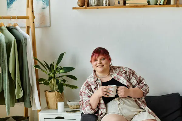 Eine Frau mit pinkfarbenen Haaren genießt zu Hause eine Tasse Kaffee. — Stockfoto