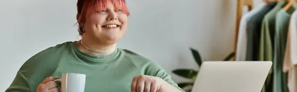 A woman with pink hair smiles while holding a cup of coffee in a home setting. — Stock Photo