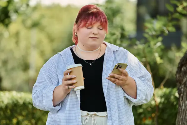 A woman with pink hair enjoys a coffee while checking her phone outdoors. — Stock Photo
