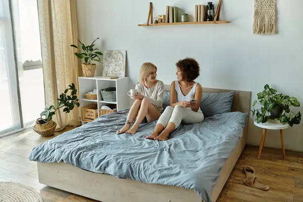 A multicultural lesbian couple enjoys a relaxed conversation in their cozy living room. — Stock Photo