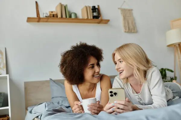 A multicultural lesbian couple spends a relaxing afternoon together in their home, sharing a laugh and a moment of intimacy. — Stock Photo