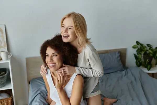 A loving lesbian couple shares a tender moment in their home, both dressed in comfortable clothes, laughing together. — Stock Photo