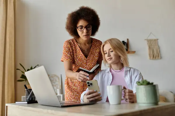A couple works from home, one on a laptop, the other on their phone. — Stock Photo