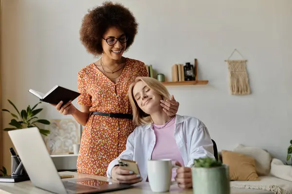 A multicultural lesbian couple enjoys a moment of affection while working from home. — Stock Photo
