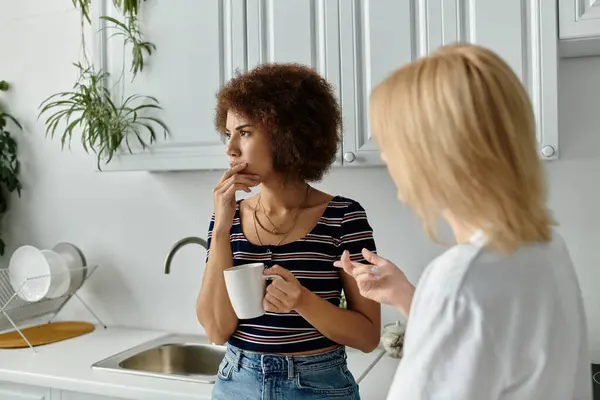 A lesbian couple argues in the kitchen, tension and misunderstanding hanging in the air. — Stock Photo