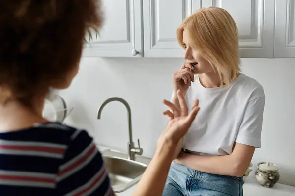 Лесбиянки ссорятся на кухне, их лица выражают недовольство и разочарование. — стоковое фото