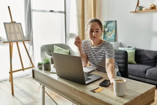 Une belle femme avec vitiligo se concentre sur son travail tout en sirotant du café. — Photo de stock